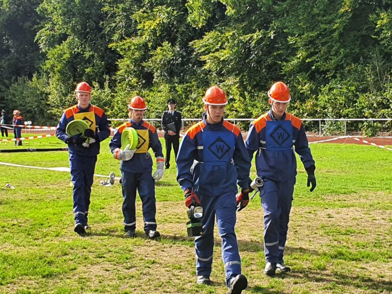 der Schlauchtrupp und der Wassertrupp von der Jugendfeuerwehr beim A-Teil auf einer Wiese