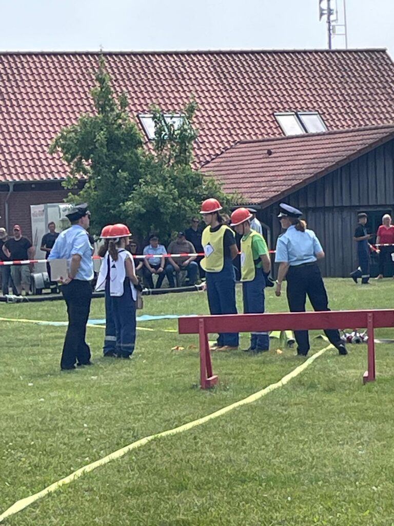 Der Schlauchtrupp nimmt am Verteiler seinen Befehl vom Gruppenführer entgegen