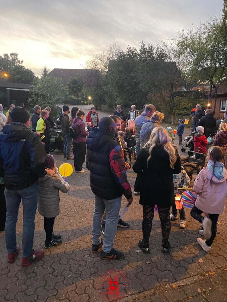 Der Laternenumzug singt ein Lied an einer Lichtung