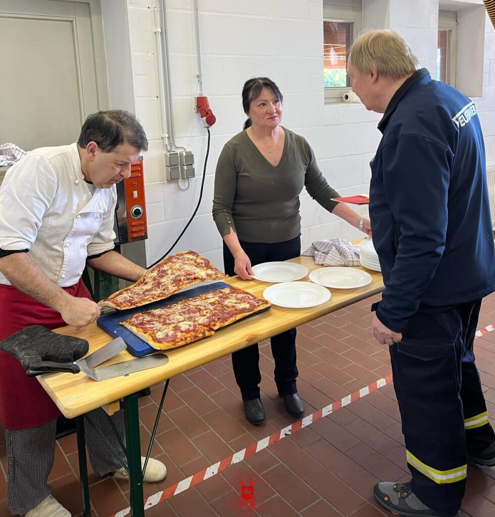 Mario und Maria schneiden die Pizzen für das Pizza essen im Feuerwehrhaus
