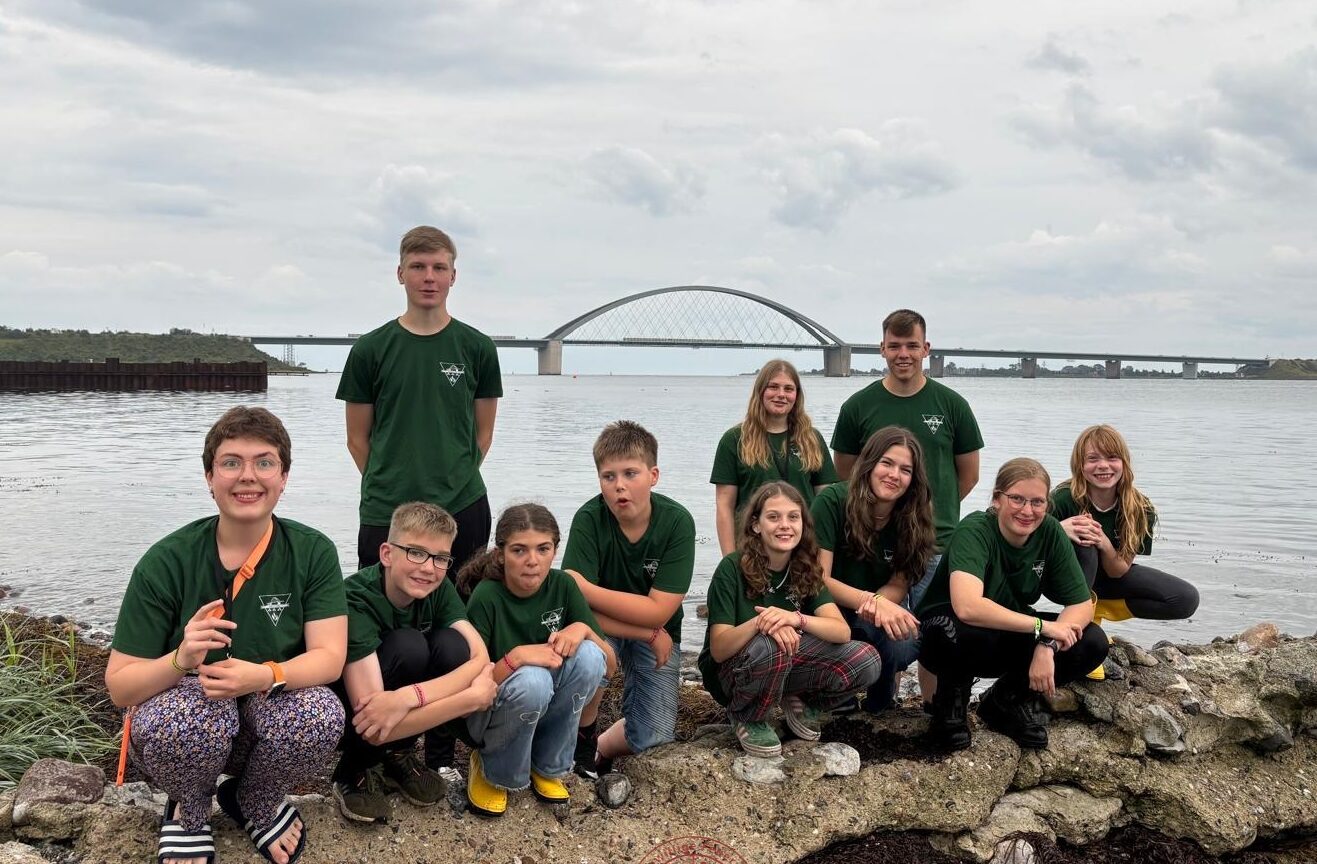 Gruppenfoto von den Jugendlichen am Strand vor der Fehmarnsundbrücke