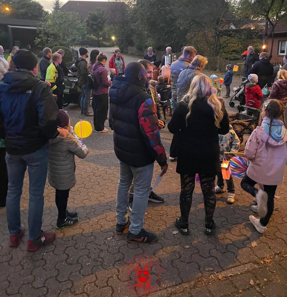 Der Laternenumzug singt ein Lied an einer Lichtung